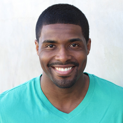 An elderly couple sharing a warm embrace outdoors.